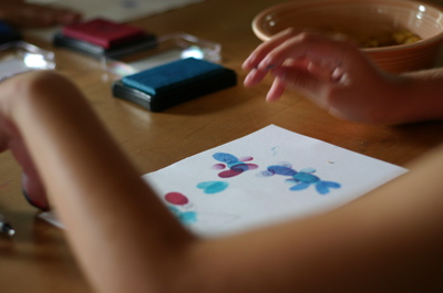 close-up of kid's hands creating thumbprint art