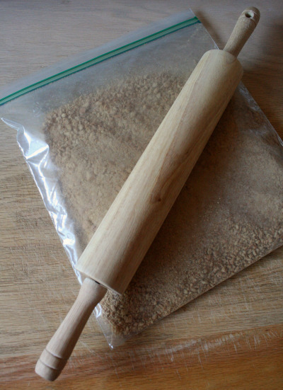 graham crackers in a plastic bag being crushed with a rolling pin