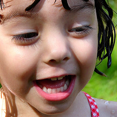 close-up photo of a preschool girl with wet hair in a bathing suit 