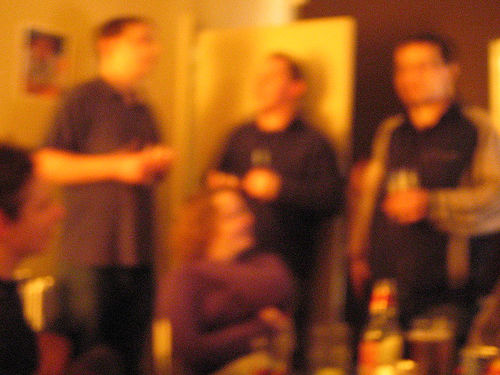 Blurry photo of people standing around at a party