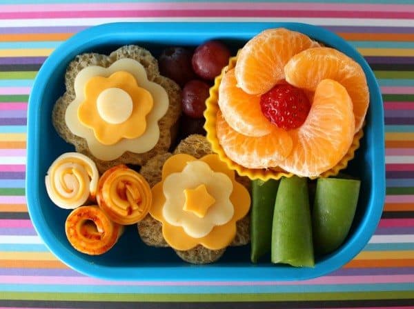 Cute bento box lunch made with fruit, veggies, meat and cheeses