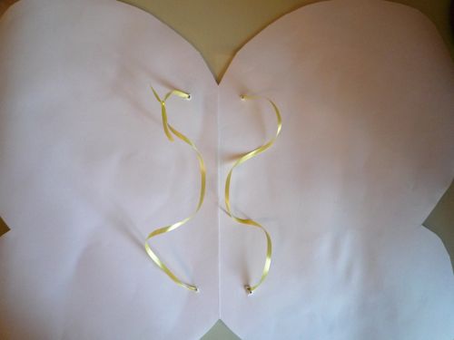 yellow ribbon tied to paper butterfly wings 