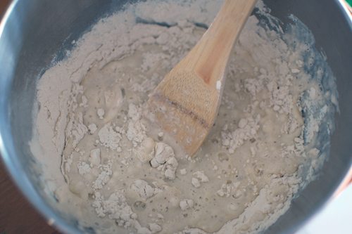 ingredients for making salt dough in a bowl with a wooden spoon