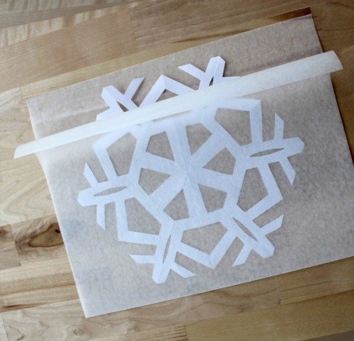 paper snowflake folder into wax paper 