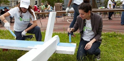 two women volunteers painting a picnic table