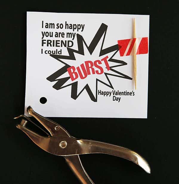 hole punch laying next to a "I am so happy you are my friend I could burst" valentine printable
