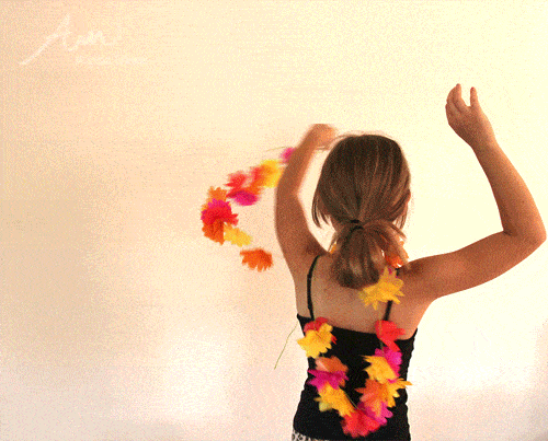 a young girl dancing with flower garland