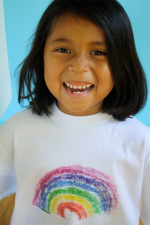 Little brunette girl wearing handmade T-shirt with rainbow printed on it