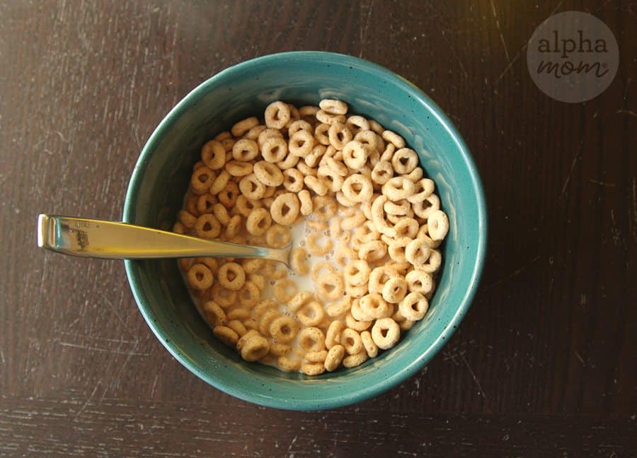 photo of Cheerios cereal in milk with spoon inside the turquoise bowl