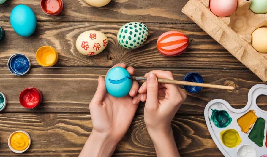 hands decorating dyed Easter eggs