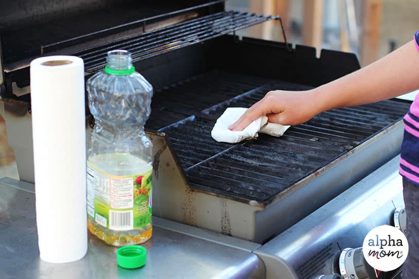 picture of hand swiping grill with vegetable oil on paper towel