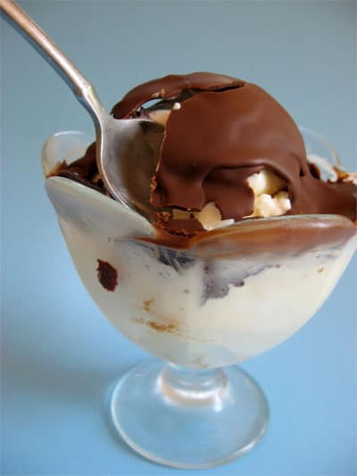 spoon broken into DIY chocolate magic shell on vanilla ice cream