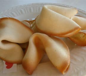 four homemade fortune cookies on crystal dish