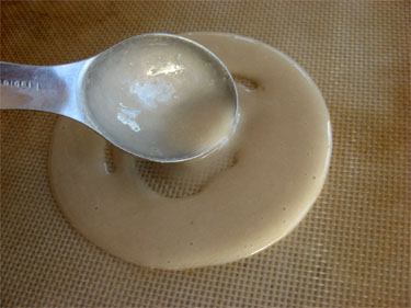 pouring and spreading the batter on Silpat mat with a teaspoon
