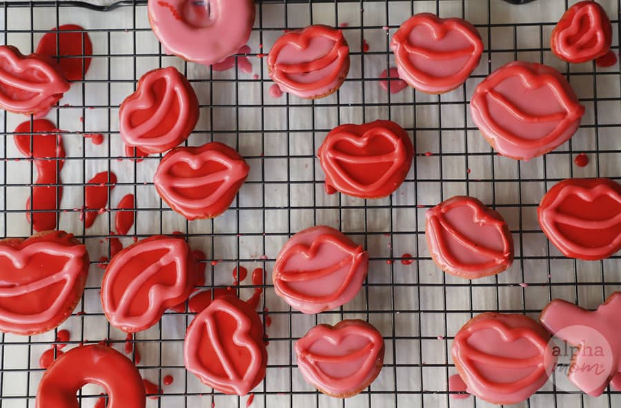 overhead photo of red lip-shaped cookies on cooling wire 