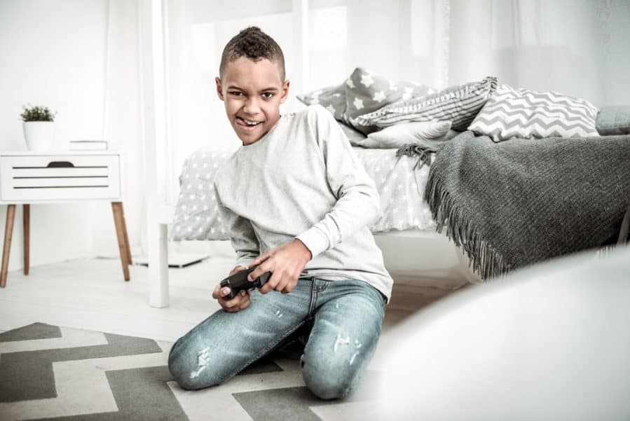 Cheerful happy boy holding a game console
