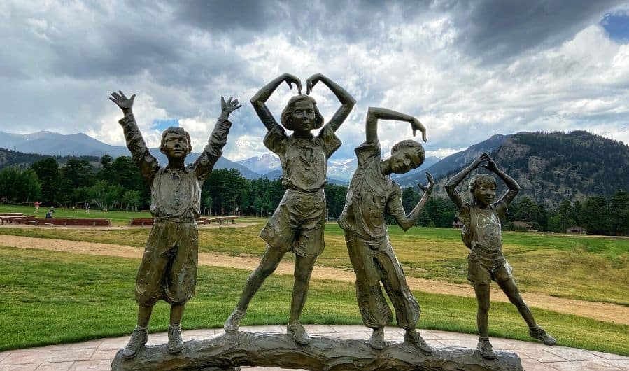 outdoor statues of kids making the YMCA sign in the Colorado Rockies