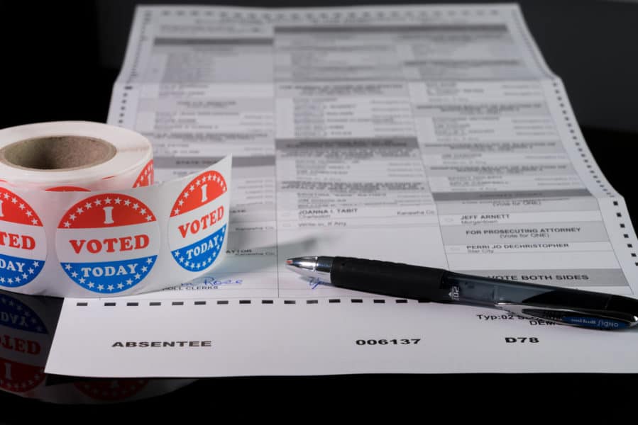 Close-up of absentee voter ballot form with I Voted Today sticker roll in foreground