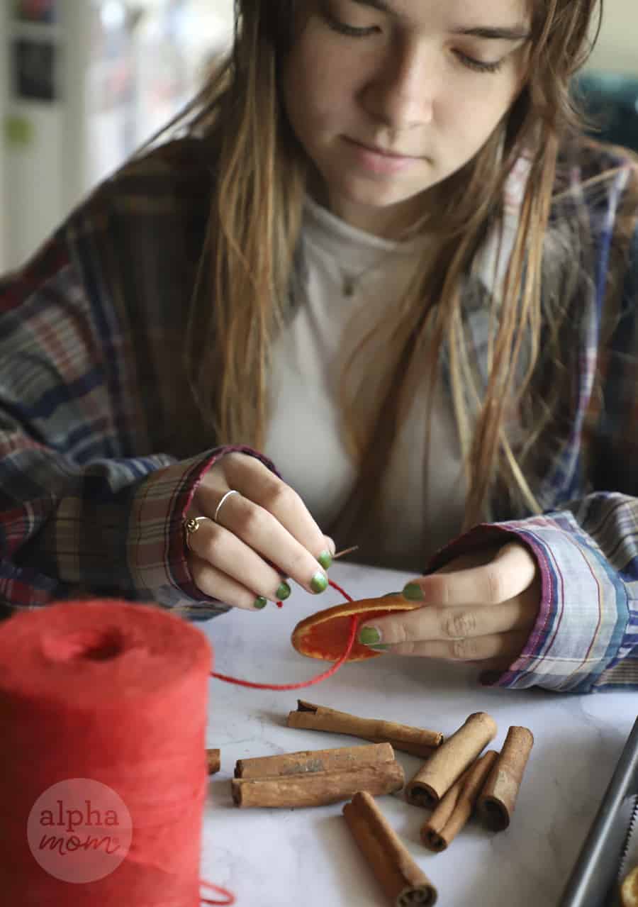 photo of teen girl sewing twine through baked citrus slice