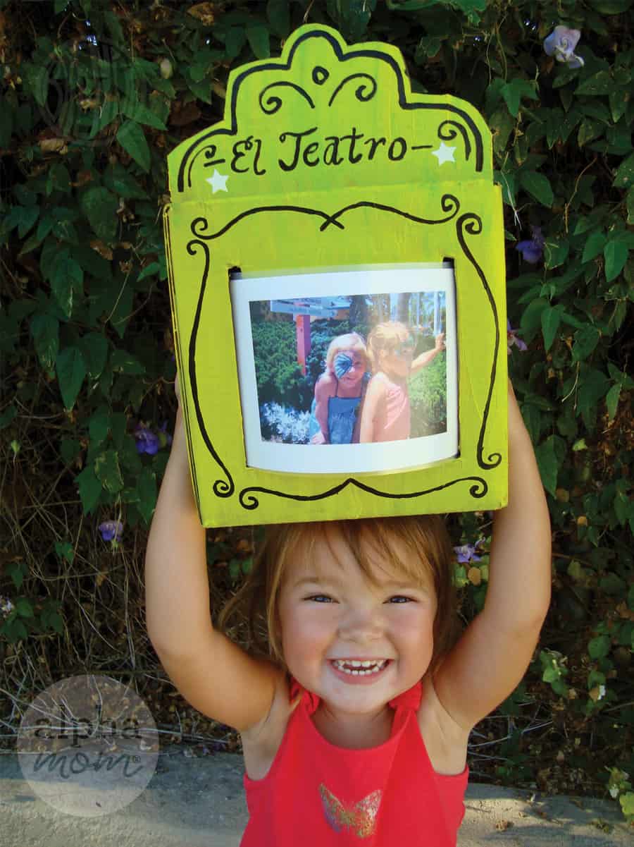 Smiley Girl holding an El Teatro handmade sign with a summer memory photo in it 