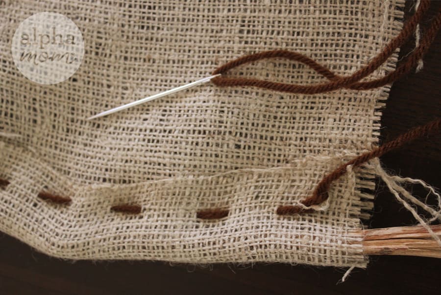 stitching burlap with needle and yarn