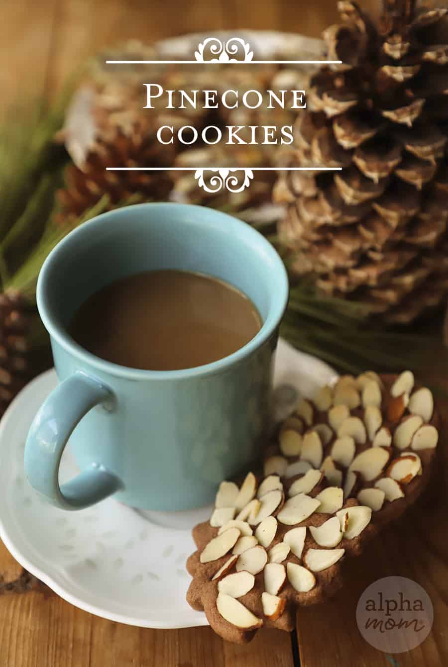 close-up of blue coffee cup with two chocolate sugar cookies with slivered almonds with the words Pinecone Cookies at the top of the photo