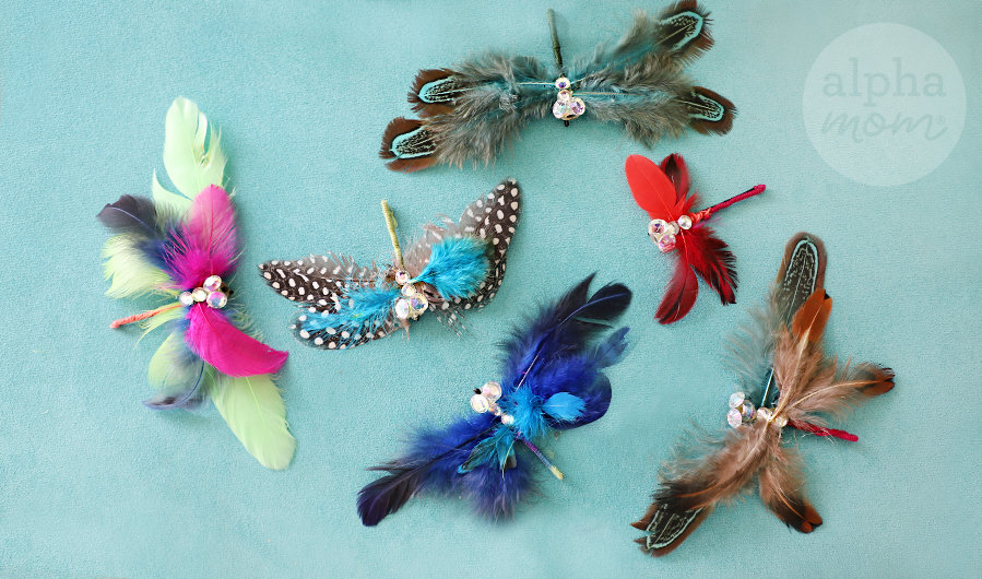 Six multi-colored and varied handmade dragonfly hairpins made from fake feather and rhinestones on turquoise background