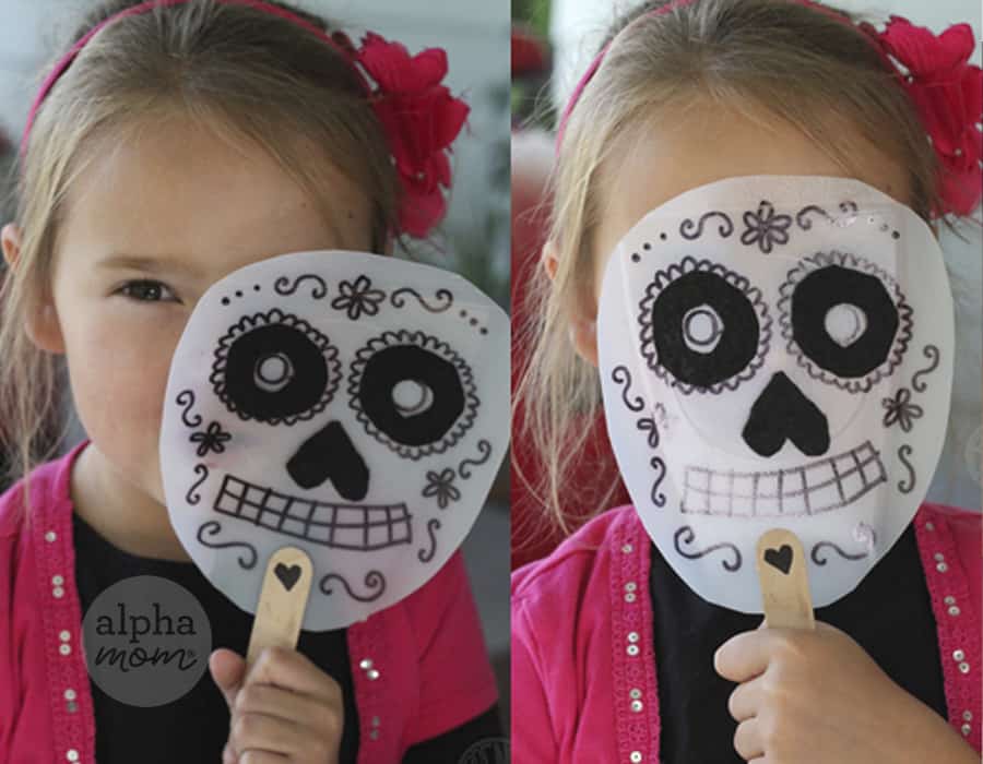 two side by side photos of blond little girl wearing pink vest over black long-sleeved shirt holding up a handmade Dia de los Muertos Mask in one shot covering face and in other revealing her face